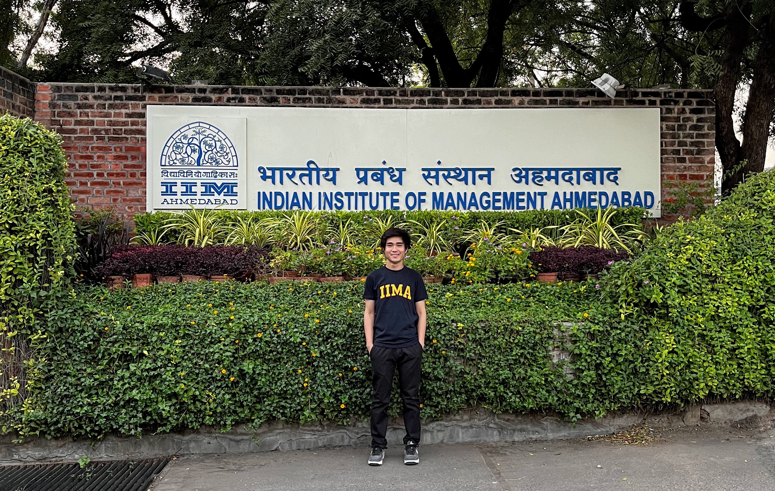 A boy in front of IIMA-sign.